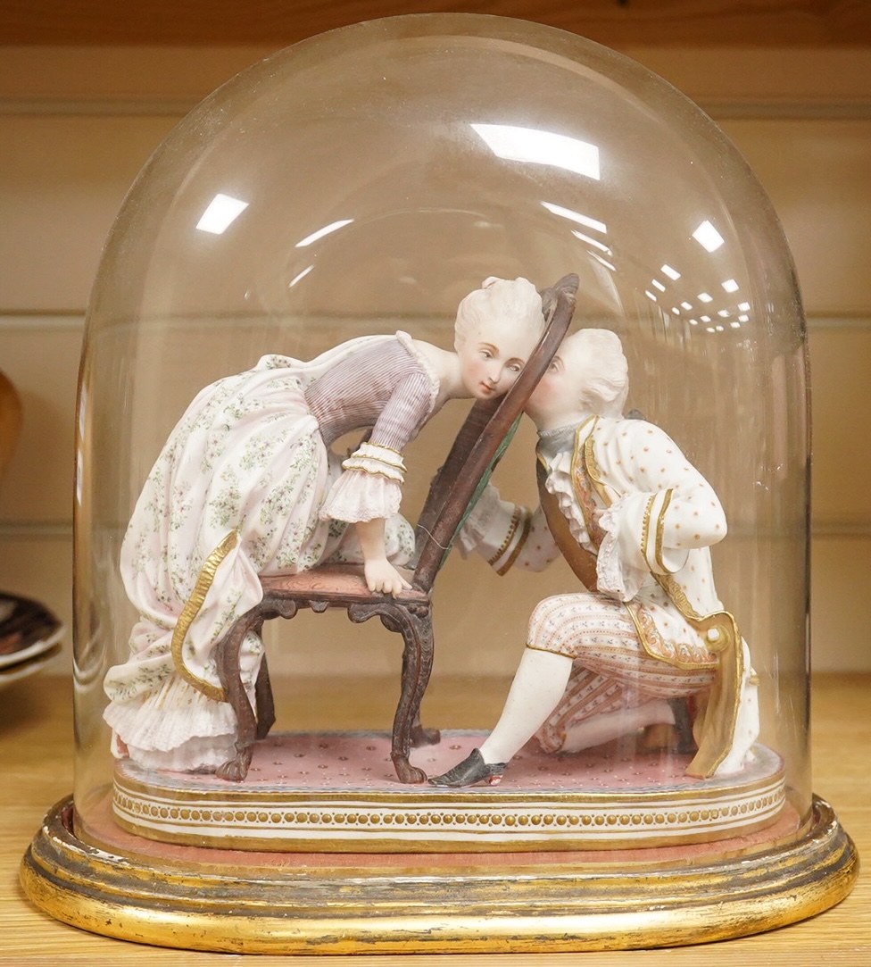 A 19th century biscuit porcelain study of a courting couple under glass dome, raised on gilt base, 28cm high